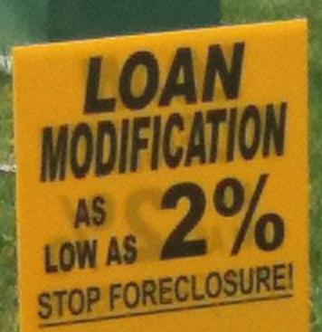 Foreclosee has yellow loan modification sign on lawn to stop foreclosure.